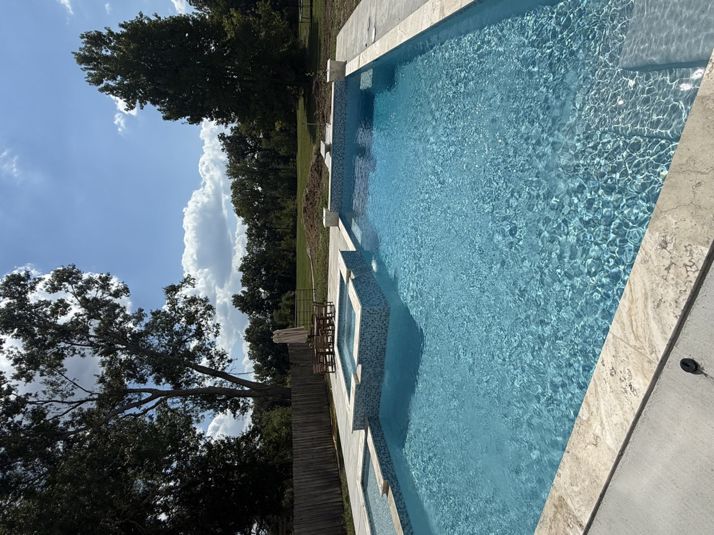 Large rectangular pool with raised spa and mosaic tile