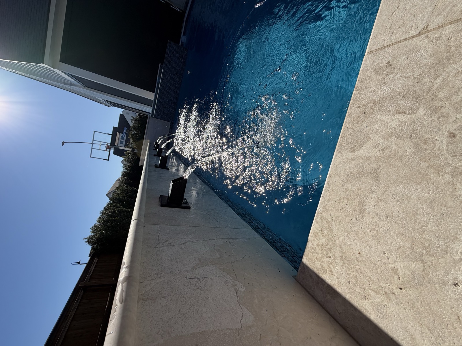 Close-up of wall scuppers with water arcing into pool