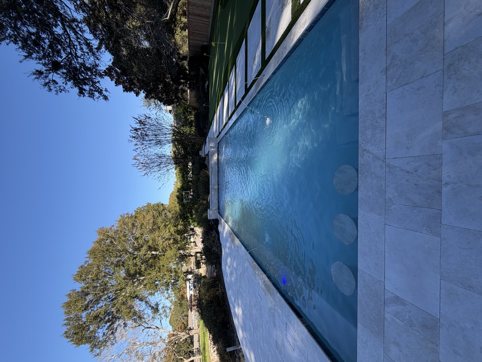 Rectangular pool with built-in ledge seating and putting green