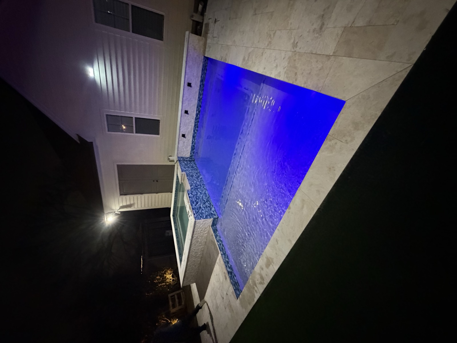 Pool and spa with blue LED lighting at night