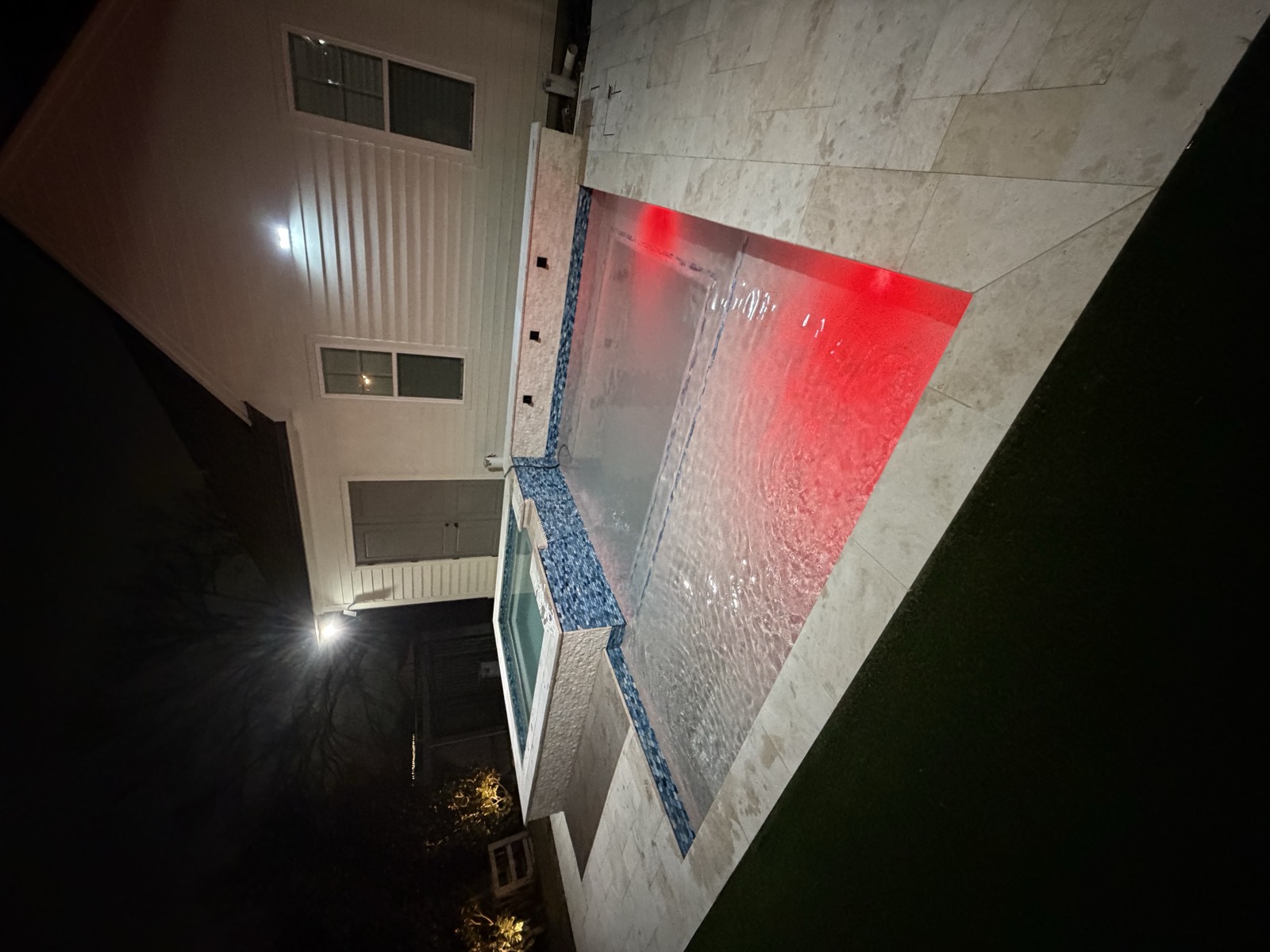 Pool and spa with red LED lighting at night